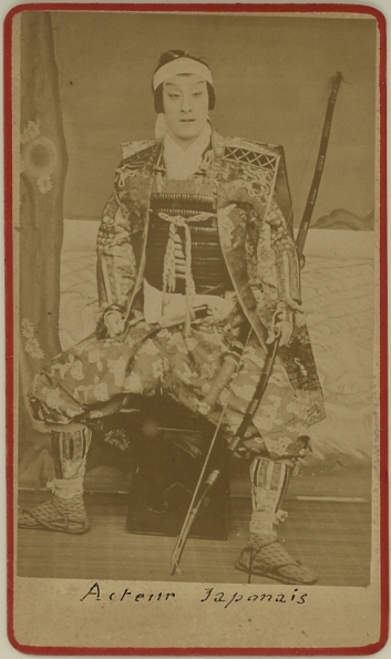 A Japanese actor dressed as warrior holding a large bow.  Ca. 1875-80