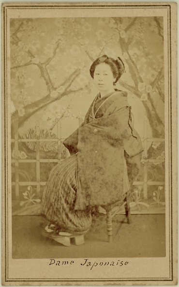 Japanese lady. Photographed seated in front of a study backdrop, she wears traditional shoes.  Ca. 1875-80