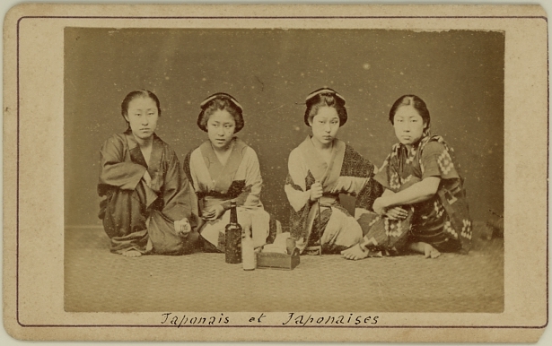 Four seated Japanese ladies in kimono. Bottles in front of them. Ca. 1875-80